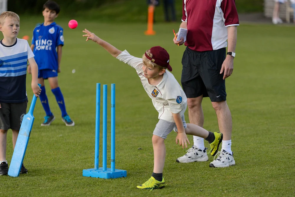 Junior cricketer pink ball throw karta coach ke saamne, underarm bowling practice in youth session